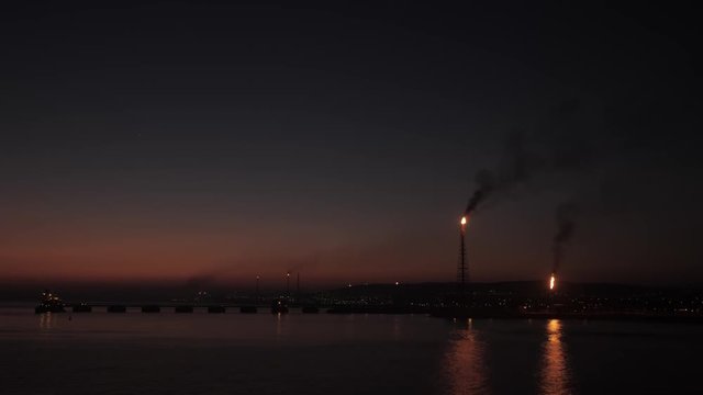 Gas flare of petrochemical refinery in sunrise