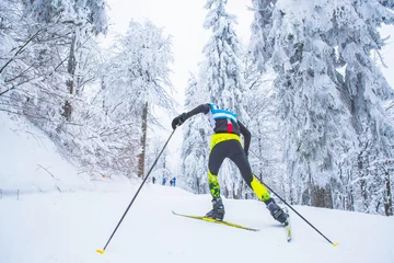 Afwasbaar fotobehang A man cross-country skiing in front of winter landscape © kovop58