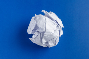 Crumpled junk paper ball on a blue background (design element)