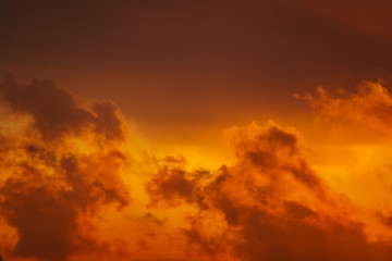 Obraz na płótnie Canvas Beautiful view of a dark silhouettes of clouds in the orange sky illuminated by the rising sun