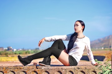 Model posing on nature sitting on stones