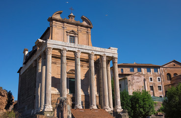 Fototapeta na wymiar Antonin and Faustine temple on contrast blue sky background in Rome, Italy