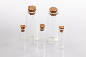 Glass container with cork stopper on white background.