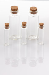 Glass container with cork stopper on white background.
