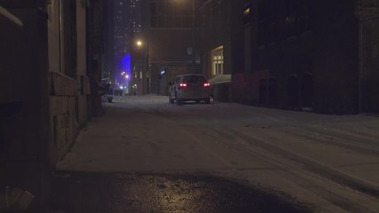 Car parked in dark alleyway in winter storm