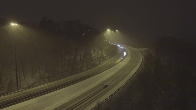 Cars driving on a highway in winter storm at hight
