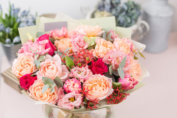 beautiful luxury bouquet of mixed flowers on pink table. the work of the florist at a flower shop.