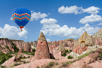 Fototapeta na wymiar Colorful hot air balloon flying over Red valley at Cappadocia, Anatolia, Turkey. Volcanic mountains in Goreme national park.