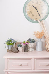 spring mood. Vintage interior decoration. pink pastel closet. Dry anf fresh flowers on wooden table. A large clock on a white wall. copy space