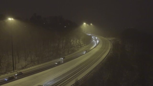 Cars driving on a highway in winter storm at hight