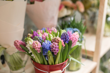 Flower shop concept. Different varieties fresh spring flowers in refrigerator room for flowers. Bouquets on shelf, florist business.
