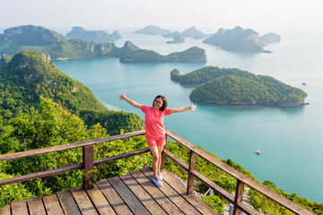 Obraz premium Woman tourist standing posing on the podium is peak view point of Ko Wua Ta Lap and beautiful nature landscape of island and sea in Mu Ko Ang Thong National Marine Park, Surat Thani, Thailand
