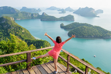 Woman tourist standing posing on the podium is peak view point of Ko Wua Ta Lap and beautiful nature landscape of island and sea in Mu Ko Ang Thong National Marine Park, Surat Thani, Thailand