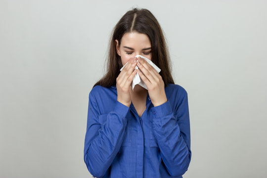 Portrait of a pretty woman  having flu. Girl blowing nose