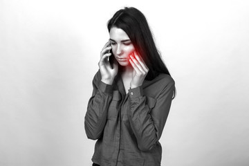Portrait of a pretty woman having toothache and calling a doctor. Black and white with a red accent