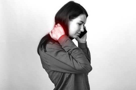Portrait of a pretty woman holding her neck in pain and discomfort calling a doctor. Black and white with a red accent