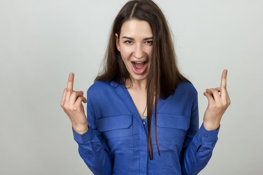 Portrait of angry girl showing middle fingers on hands.