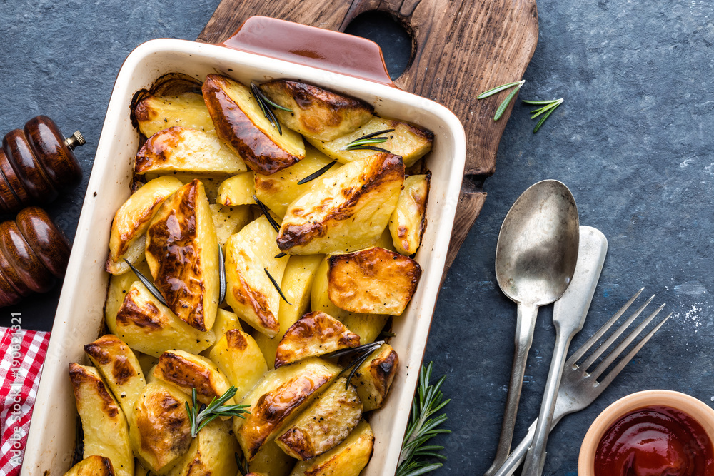 Wall mural crispy spicy baked potatoes in baking dish