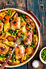 Chicken thighs baked with potato, carrot and green peas