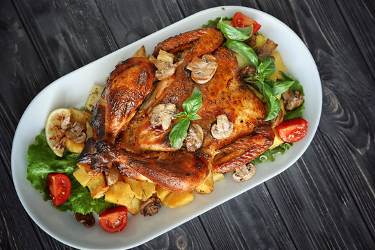 Delicious whole roasted chicken served on wooden table