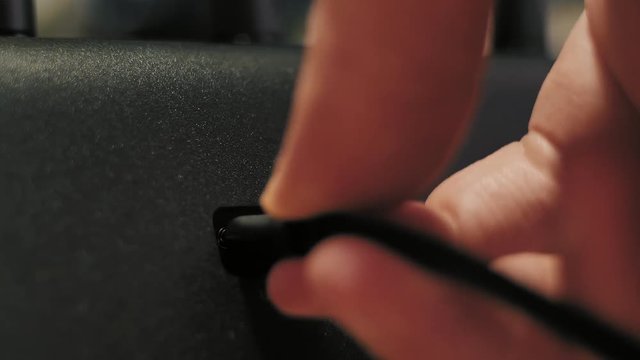 Man's hand plugging in and out usb C cord to electrionic device.