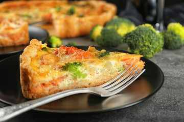 Plate with tasty broccoli quiche on table