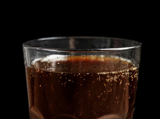Glass of refreshing cola on black background, closeup