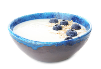 Yogurt with blueberry and oat flakes in dish on white background