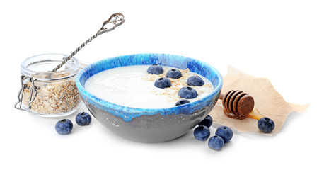 Yogurt with blueberry and oat flakes in dish on white background