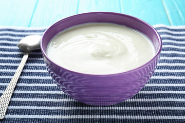 Tasty yogurt in dish on napkin