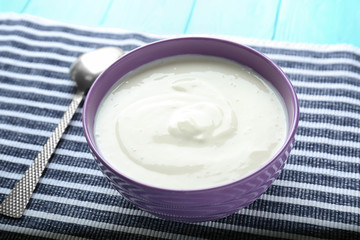 Tasty yogurt in dish on napkin