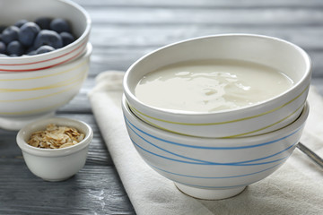 Tasty yogurt in dish on wooden table
