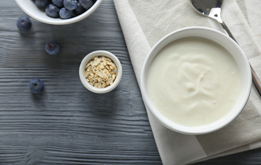 Tasty yogurt in dish on wooden table