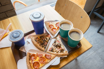 Pizza slices with salami and mushrooms, coffee, drinks.