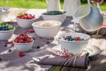 Healthy breakfast with raspberries and blueberries in sunny day