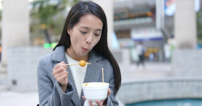 Business woman enjoy fish ball at outdoor