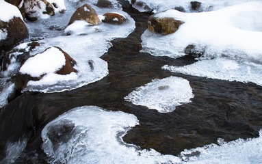 Patches of ice cover a small stream and cling to rocks in the Tongariro National Park, New Zealand.