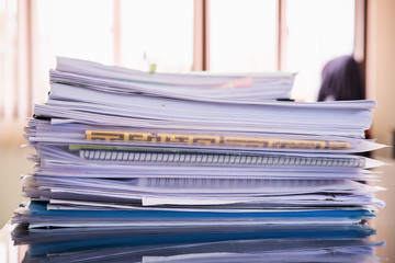 Close up paper stack on the desk related to business functions.Stack of business document files,report paper of accounting and financial with morning light,soft focus