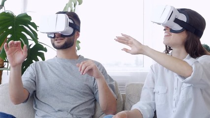 Couple sitting on the sofa in 3D glasses - Powered by Adobe
