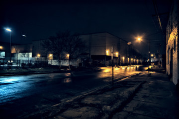 Fototapeta na wymiar Industrial urban Chicago scenery at night with a warehouse and street reflections after a rain.