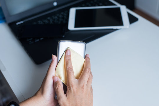 Hand Woman Cleaning Her Smart Phone With Microfiber Cloth