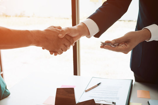 real estate agent shaking hands to his client after signing contract agreement in office,concept for real estate, moving home or renting property