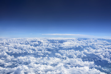 View from above of clouds that cover the planet until the blue horizon