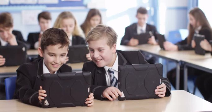 4k, High school pupils using tablet pcs in classroom. Slow motion.