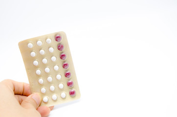 Contraceptive pill in Asian women's hand. White background
