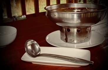 Spoon on a white plate on the table.