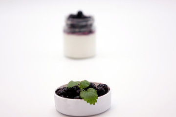 Fresh berries in the jar with the yogurt. On white background.