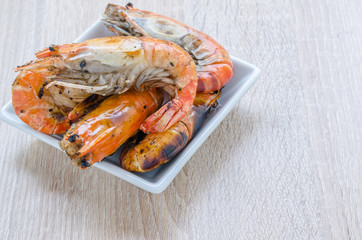 Thai style barbecue, grilled shrimp on wooden background