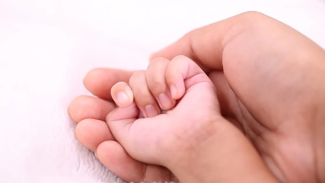 Baby and mother hands together