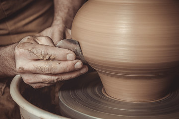 elderly man making pot using pottery wheel in studio - obrazy, fototapety, plakaty